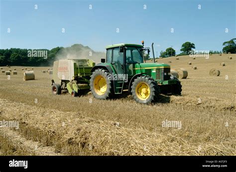 Claas Round Baler And John Deere Tractor Baling Wheat Straw Stock Photo