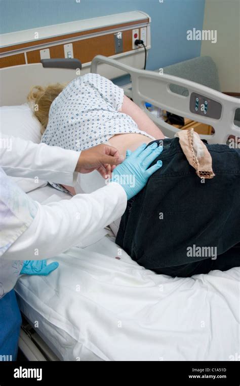 Nurse Changing Surgical Dressing On Patient After Back Surgery In Stock