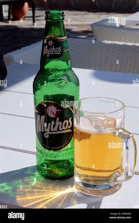 Single Green Mythos Greek beer bottle - and glass of Mythos partially ...