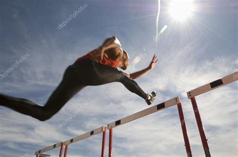 Male Athlete Jumping Hurdle Stock Photo By ©londondeposit 33820919