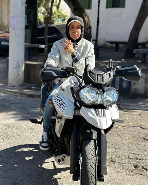 A Man Riding On The Back Of A White Motorcycle