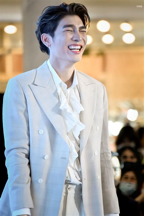 A Man In A White Suit And Tie Smiling