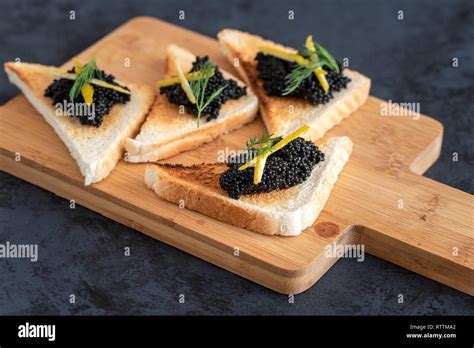 Appetizer Toast Bread With Black Caviar Decorated By Lemon Pill And