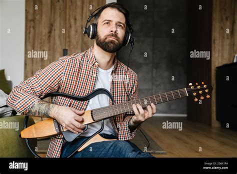 Smiling Mid Aged Brunette Bearded Man Playing Acoustic Guitar While