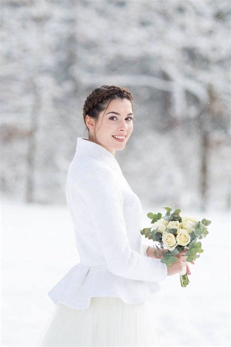 A Woman Holding A Bouquet Of Flowers In The Snow