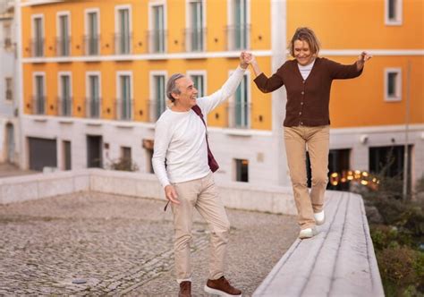 Premium Photo Joyful Mature Tourists Couple Walking Holding Hands