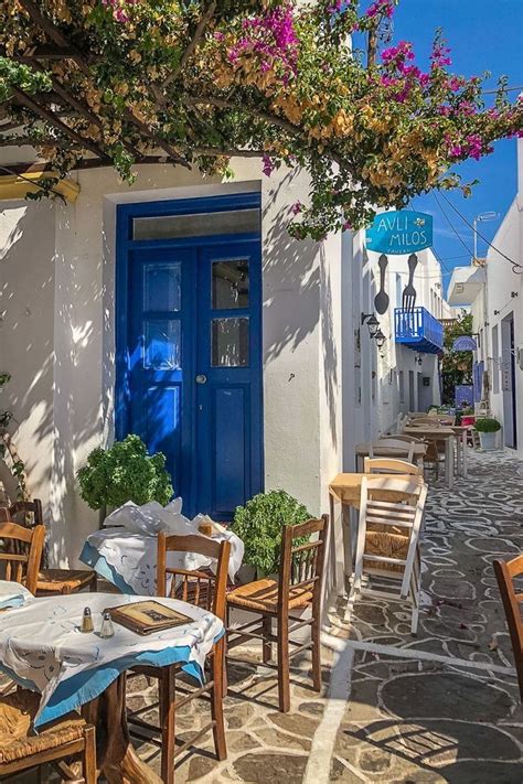 An Outdoor Dining Area With Tables Chairs And Umbrellas On The Side Of