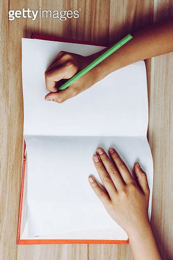 Close shot of a human hand writing something on the paper 이미지