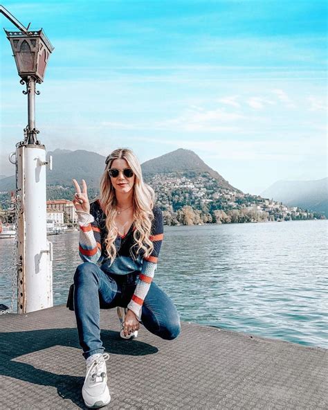 A Woman Sitting On Top Of A Pier Giving The Peace Sign With Her Hand