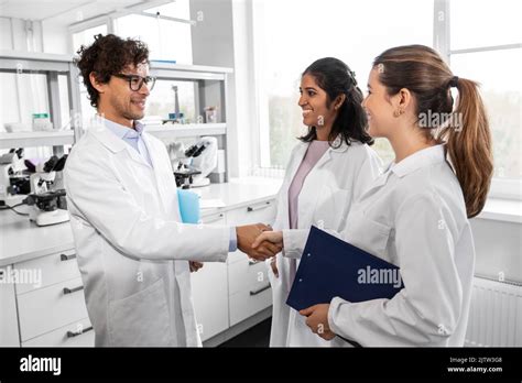 Scientists Shaking Hands In Laboratory Stock Photo Alamy