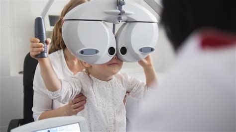 Optometrista De Oftalmología Infantil Comprueba El Ojo De La Niña