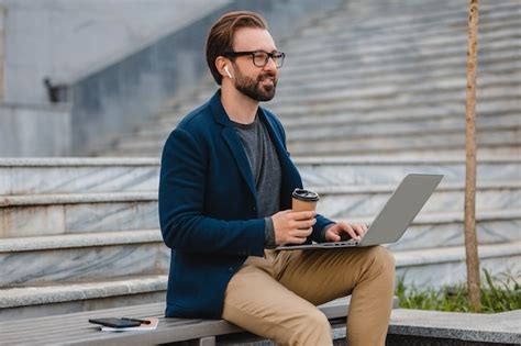 Free Photo Handsome Smiling Bearded Man In Glasses Working On Laptop