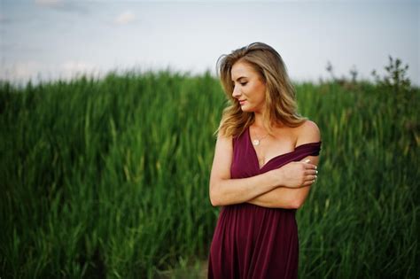 Femme Sensuelle Blonde En Robe Marsala Rouge Posant Dans Les Roseaux Photo Gratuite