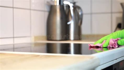 A Man Wearing Cleaning Gloves Wipes The Induction Hob Stock Footage