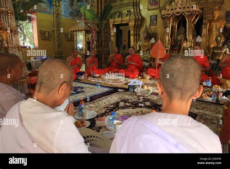 Seated Buddhist Monks Chanting And Reading Prayers At A Buddhist