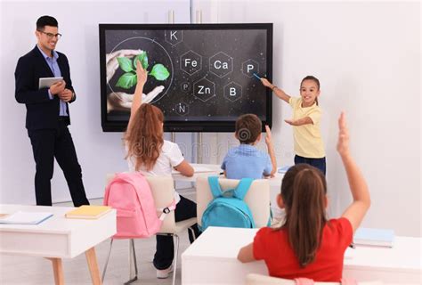 Teacher and Pupil Using Interactive Board in Classroom during Lesson Stock Photo - Image of ...