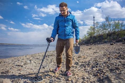 Le Chasseur De Trésor Avec Un Détecteur De Métaux Dans Des Ses Mains