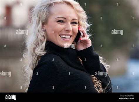 Blonde Woman Talking On Her Mobile Phone Smiling Stock Photo Alamy
