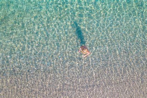 Vista Superior Joven Hermosa Mujer Desnuda En Un Sombrero Sacando Bikini En Agua De Mar Foto