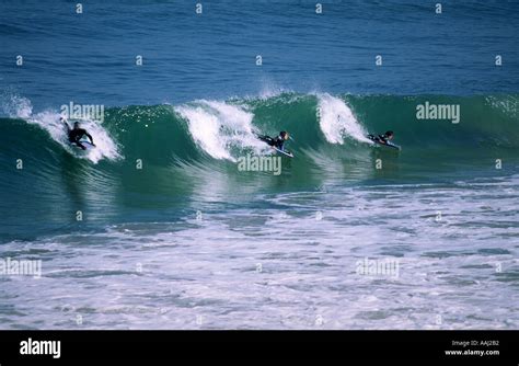 Three Surfers In A Wave Stock Photo Alamy