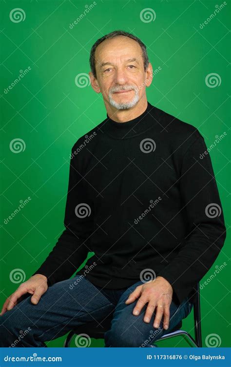 Portrait Of A Mature Gray Haired Man With Well Trimmed Beard On A Green