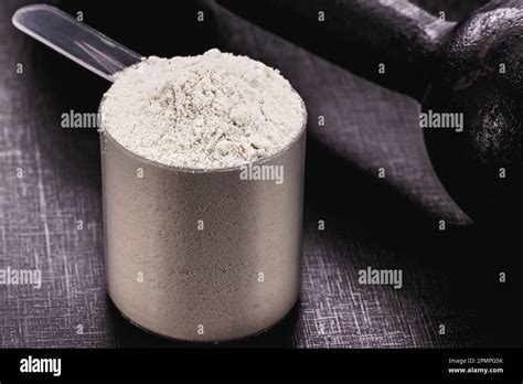 Casein In Measuring Spoon Black Background With Weights And Weight