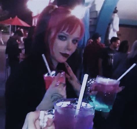 A Woman With Red Hair Holding Two Drinks