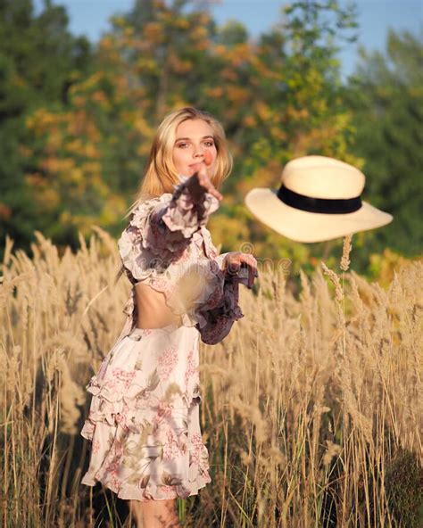 Blonde Woman Stands In The Forest With A Bouquet Of Wheat Spikelets In