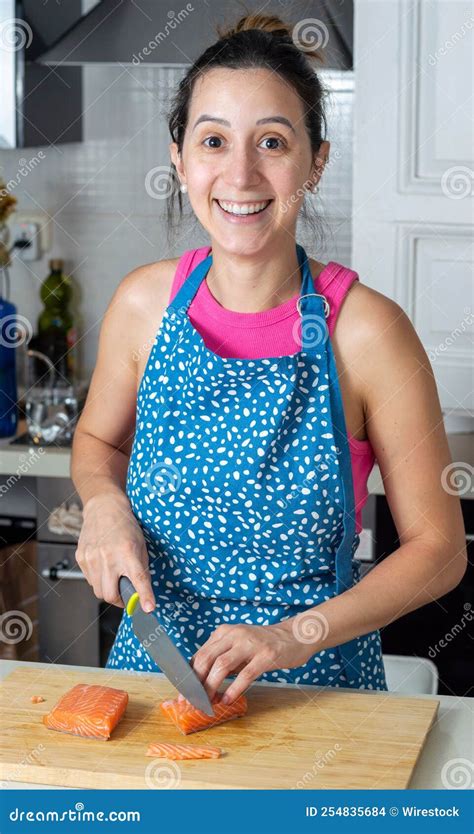 Happy Female Cutting Fresh Salmon Fillet On A Wooden Plank Stock Photo