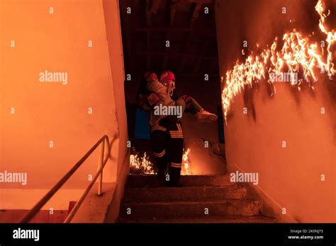 Brave Fireman Descends Stairs Of A Burning Building And Holds Saved