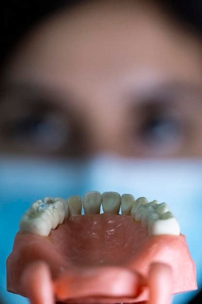 La Mujer Dentista Tiene Dentaduras Postizas En Sus Manos E Instrumentos