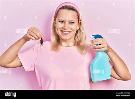 Beautiful Caucasian Blonde Woman Holding Cockroach And Pesticide