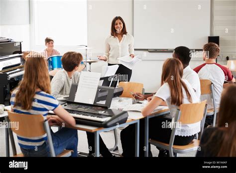 Los estudiantes adolescentes que estudian en la clase de música con la