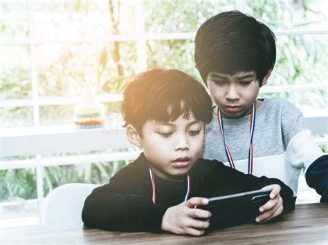 Two Little Boys Playing Online Game On Mobile Phone Stock Photo Image