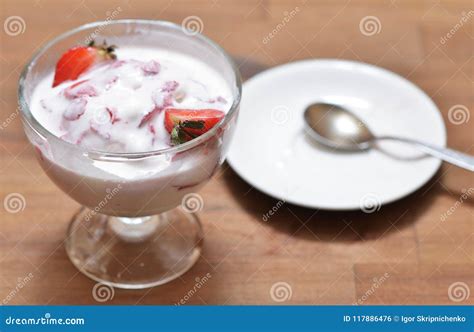 Melted Vanilla Ice Cream With Strawberry Slices Mixed In A Glass Bowl