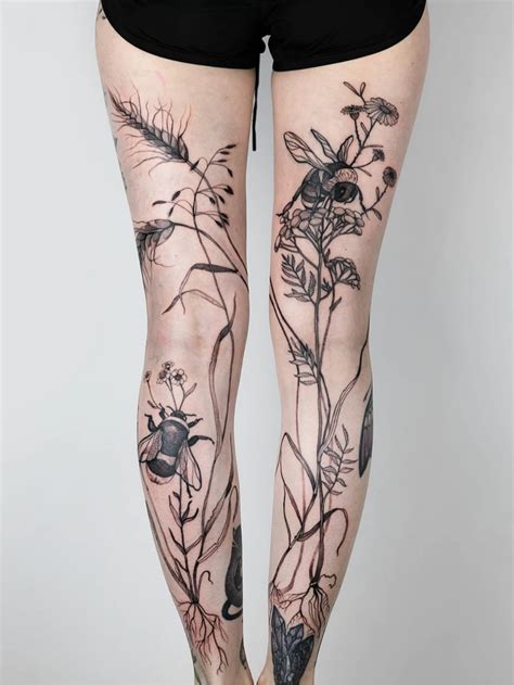 A Womans Legs With Tattoos On Them And Flowers In The Bottom Right Leg