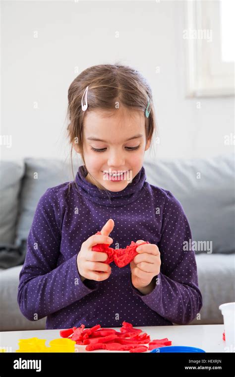 Little Girl Kneading Red Modeling Clay Stock Photo Alamy