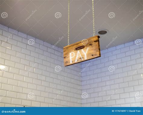 Wooden Pay Sign Hanging Over Cash Register Payment Area In Cafe Stock