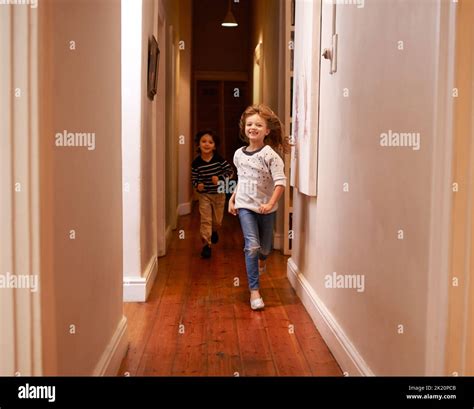 Dont Run In The House Two Children Running Down A Hallway Stock Photo