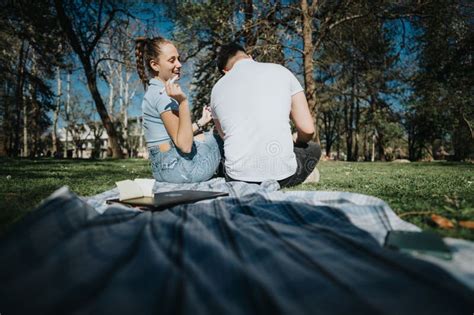 High School Students Studying Together In A Park Collaborating On A