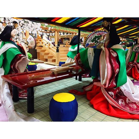 Two Women In Traditional Japanese Garb Sitting At A Table With Colorful