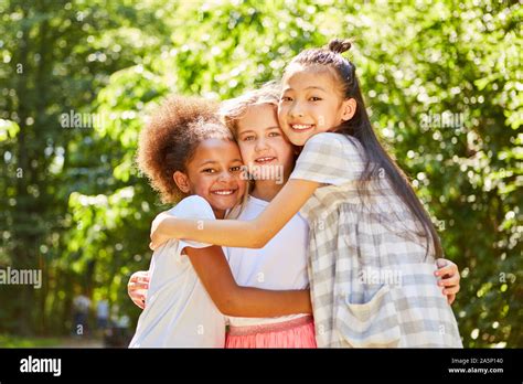 Three Multicultural Girls Hugging Each Other As Best Friends Stock