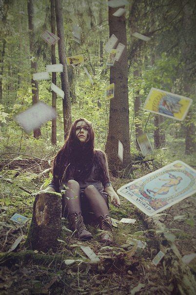 A Woman Sitting On A Tree Stump In The Woods Surrounded By Papers