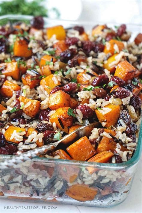 A Glass Casserole Dish Filled With Rice Cranberries And Other Vegetables