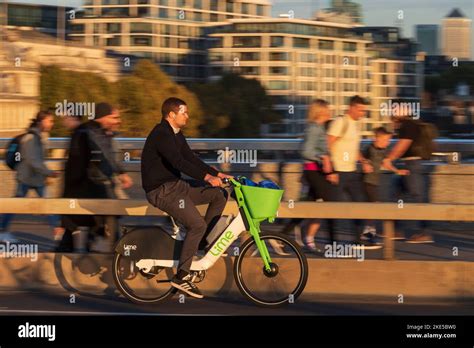 Un homme qui fait la navette sur un vélo électrique Lime à travers le