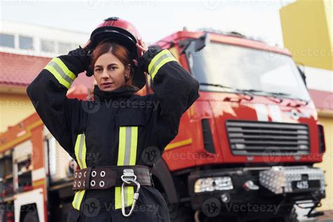 Female firefighter in protective uniform standing near truck 15360890 ...