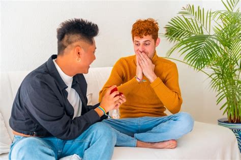 Lindo casal gay sendo romântico no sofá homem do conceito lgbt pedindo casamento Foto Premium