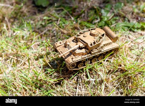 Gold tank plastic toy laying on the ground. Golden tank, military ...