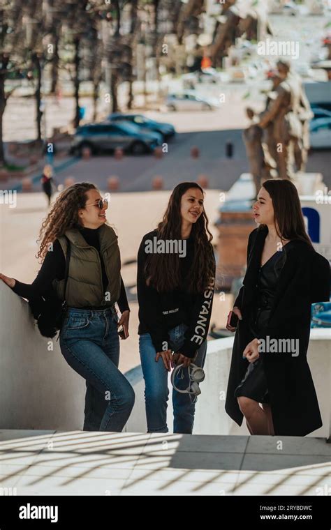 Lovely Brunette Girl Walking Upstairs At The Mall While Telling A Fun Story To Her Female