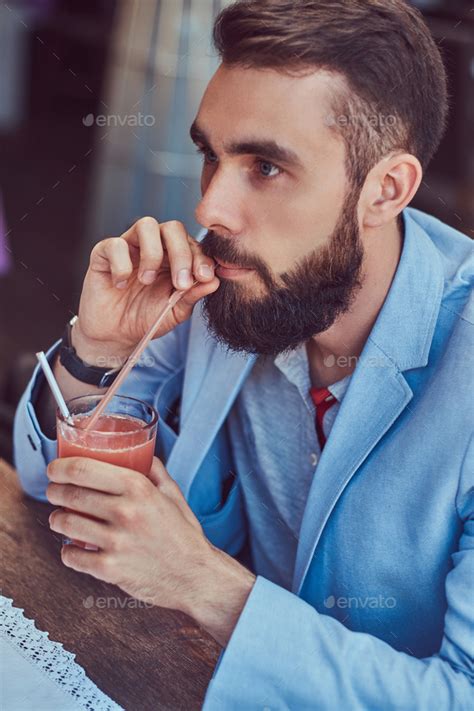 Fashionable Bearded Male With A Stylish Haircut Sitting In A Cafe